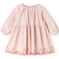 A light pink long-sleeve baby dress with a tiered skirt and red embroidered cat and floral border details along the hem, shown on a plain white background.