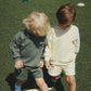 Two children playing with a soccer ball on grass