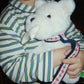 Child holding a white teddy bear with a dark background