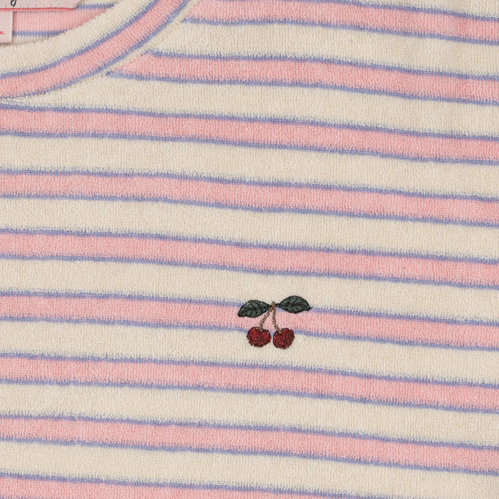 Close-up of a striped shirt with cherry embroidery on a pink and white background