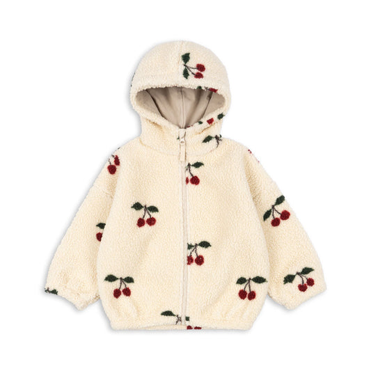 Konges Sløjd cream-colored sherpa fleece jacket for toddlers, featuring an all-over red cherry print, front zipper closure, elastic cuffs and hem, and a hood with beige inner lining. Shop at Sonny Beaar