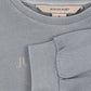 Gray sweater with 'Konges Slojd' label and text on fabric