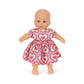 Doll wearing a pink dress with heart patterns on a white background