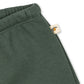 Green pants with a brand tag on a white background