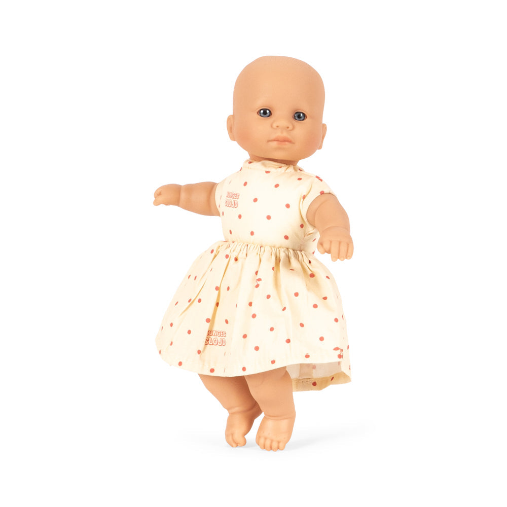 Baby doll wearing a white dress with red patterns on a white background