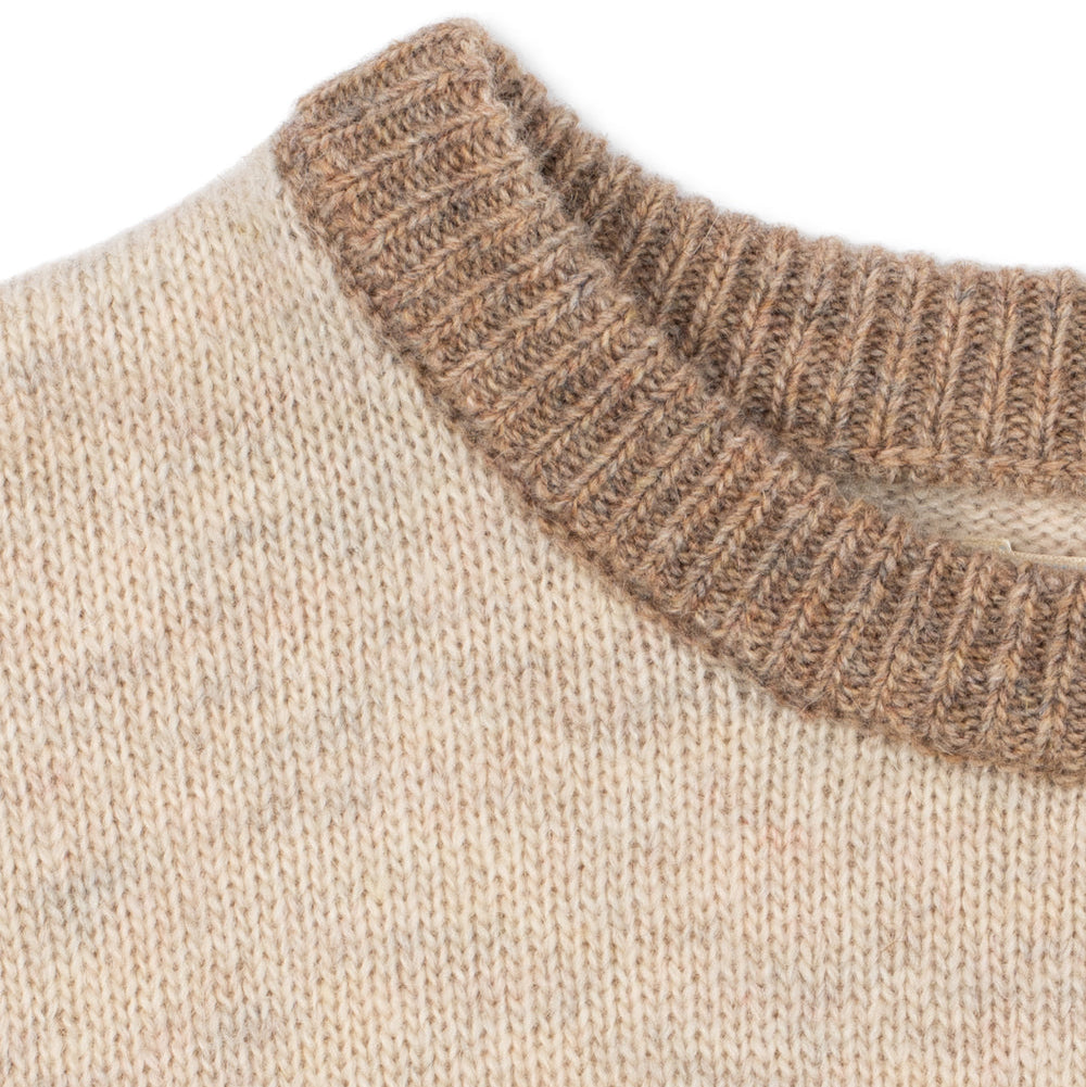 Close-up of a beige sweater with a brown ribbed neckline on a white background