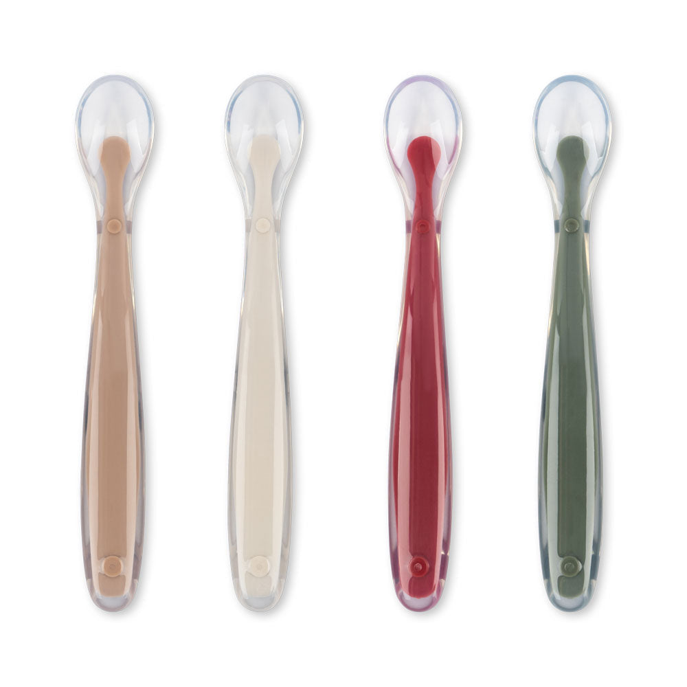 Four baby spoons with silicone heads and wooden handles on a white background